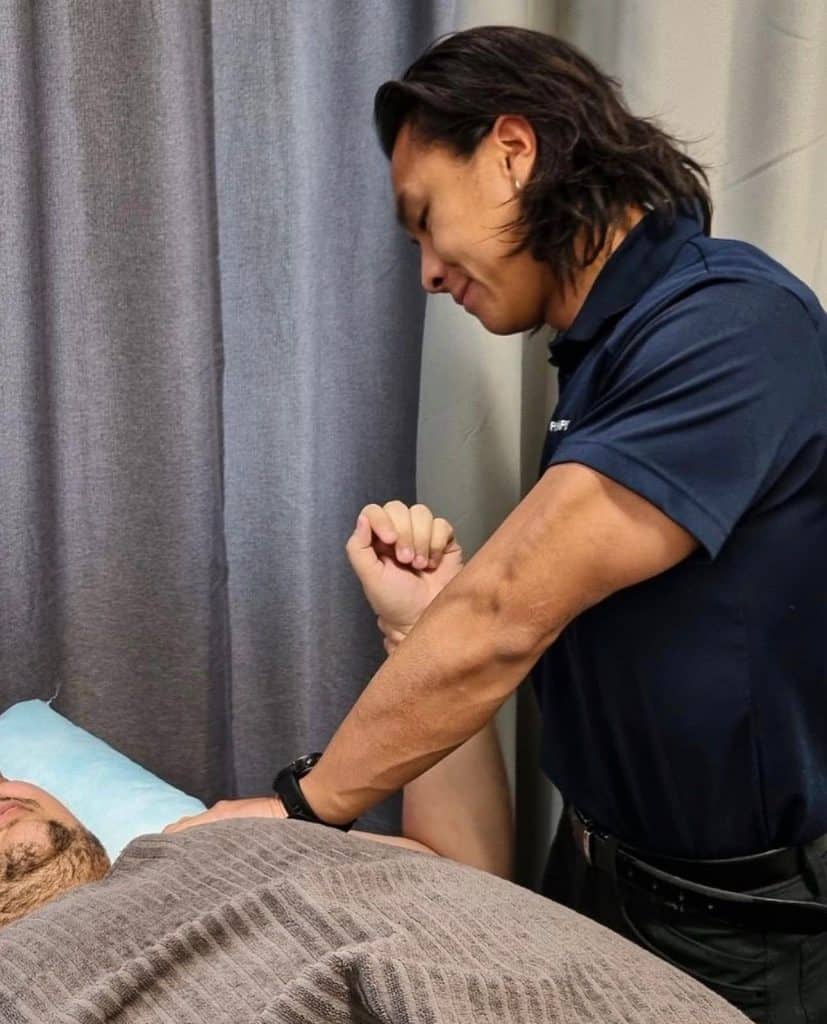 Lucus Leung, Gold Coast physiotherapist, treating a patient during a mobile physiotherapy session